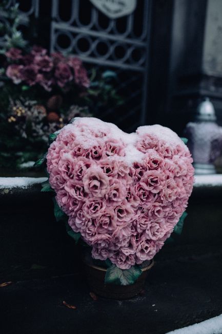 A heart-shaped floral arrangement composed of numerous pink roses with tightly packed, velvety petals, creating a dense, textured surface. The roses are fresh, vibrant, and uniformly colored, with gre